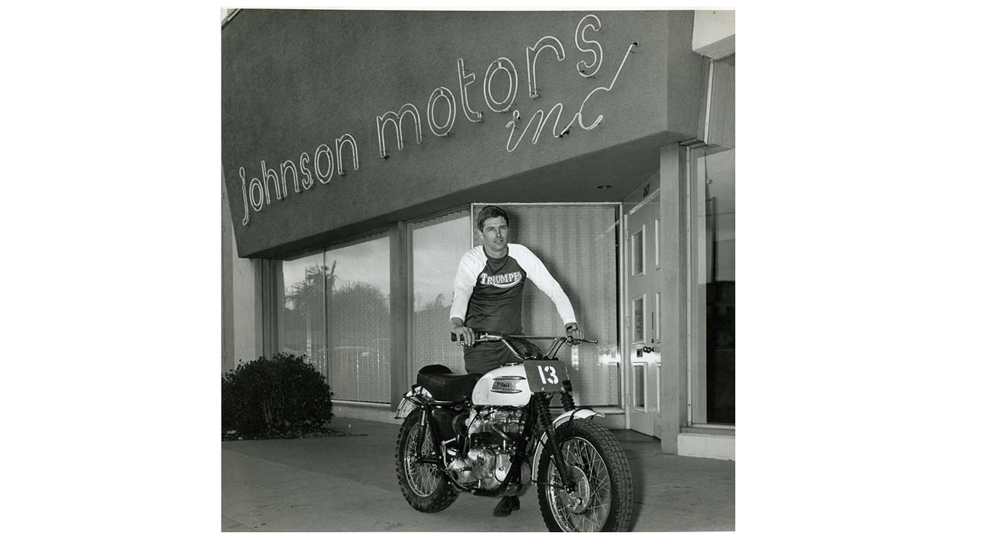 Johnson-motors_Bud-pushes-bike-1410x793.jpg