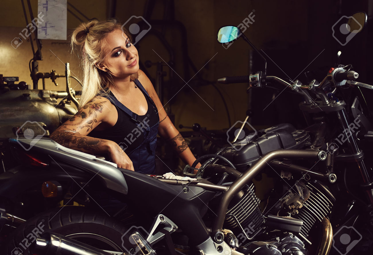 63931816-Blond-woman-mechanic-in-a-motorcycle-workshop-Stock-Photo.jpg